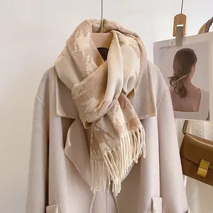 Detail of houndstooth wool scarf with horse pattern and fringe on beige coat
