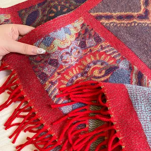 Detail of bohemian red knit scarf with ethnic floral pattern and long fringe tassels