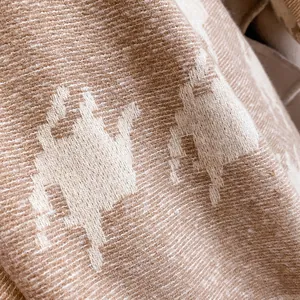 Macro shot of thick houndstooth wool scarf showing camel pattern and soft fabric texture