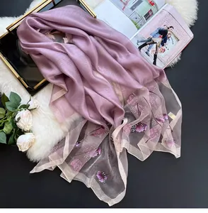 Detail of pink silk blend scarf featuring floral embroidery and pearl embellishments