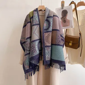 Bohemian knit shawl with colorful mandala patterns and tassels on a wooden hanger
