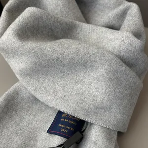 Detail of soft brushed wool scarf texture with classic 2024 woven brand label
