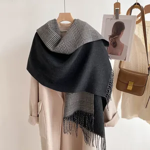 Detail of double-sided thick scarf with grey solid color and classic plaid fringe tassels