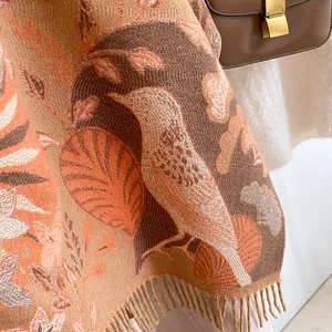 Détail d'une écharpe en maille à motif oiseaux bohème avec des finitions à franges douces