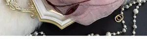 Macro detail of silk blend scarf featuring purple floral embroidery and beadwork accents
