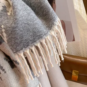 Close-up of houndstooth wool scarf texture featuring thick knit fringe and soft fabric