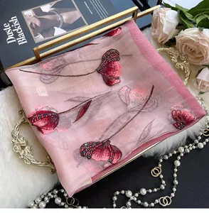 Detail of pink silk scarf with floral tulip embroidery and beaded accents on fabric
