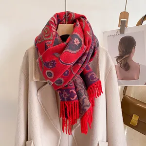 Ethnic style thick red knit scarf with fringe displayed on a beige winter coat