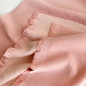 Close-up of soft pink twill cashmere-like fabric with elegant fringe edge detail