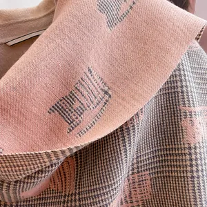 Detail view of pink and grey check scarf texture with soft cashmere weave finish
