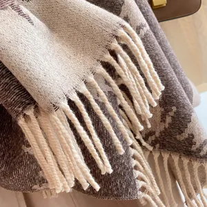 Close-up of thick houndstooth wool scarf texture with soft woven fringe details