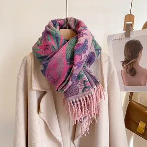 Détail d'un châle jacquard à fleurs colorées avec franges sur un manteau beige