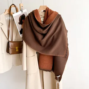 Close-up of double-sided knit scarf with tassels in dark brown and caramel tones