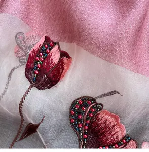 Macro detail of silk blend scarf featuring floral tulip embroidery and beaded accents