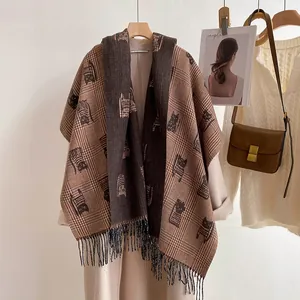 Detail of warm double-sided scarf with cat jacquard pattern and long tassels