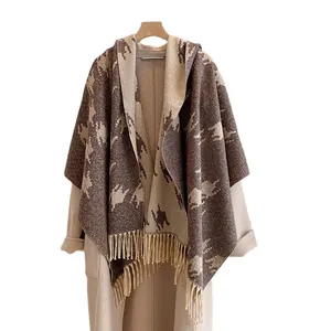 Houndstooth hooded wool shawl with fringe detail shown on a beige winter coat