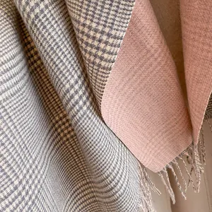 Detail of double-sided scarf with grey houndstooth pattern and soft pink solid reverse