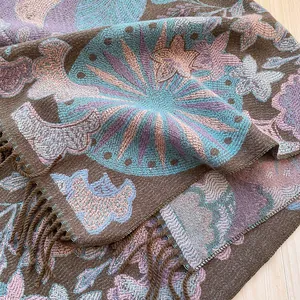 Gros plan d'un châle jacquard bohème montrant des motifs floraux et des détails de franges