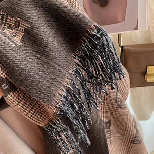 Close-up of thick plaid scarf with cute cat silhouettes and fringe details