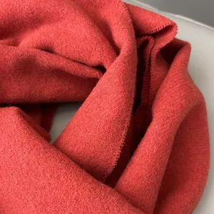 Detailed macro view of the soft Angora red wool fabric texture and edge stitching