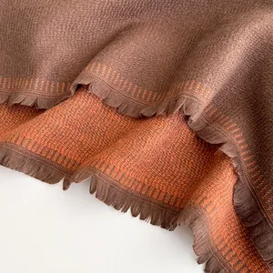 Detail of soft twill cashmere feel scarf showing fringe and bicolor knit texture