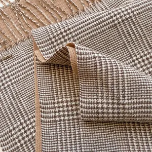 Close-up of soft cashmere-like brown plaid scarf with fringe texture and thick knit detail