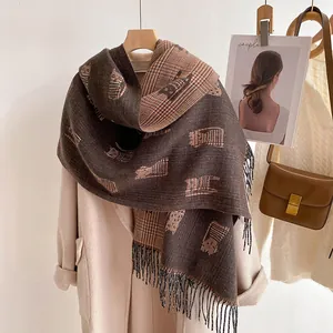 Detail of double-sided winter scarf with cat print, classic plaid, and fringe tassels