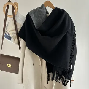 Detail of double-sided wool scarf with long tassels and premium cashmere texture