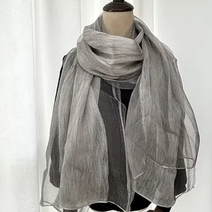 Detail of grey lightweight silk scarf with elegant pleated texture on a mannequin
