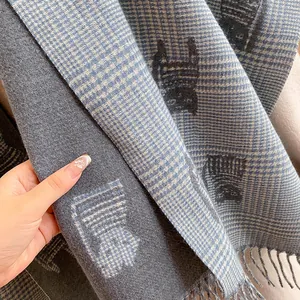 Detailed close-up of double-sided woven scarf with cat patterns and soft fringe trim