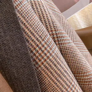 Close-up of thick houndstooth scarf texture with warm brown and beige woven fibers