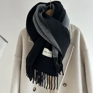 Detail of wool blend scarf with fringe edges and grey-black double-sided color blocking