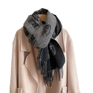 Elegant black and grey plaid scarf with fringes styled on a beige coat for autumn winter