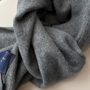 Detail of dark grey wool scarf showing fine fiber texture and elegant woven label