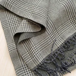 Detail of grey plaid scarf showing thick twill weave texture and twisted rope tassels