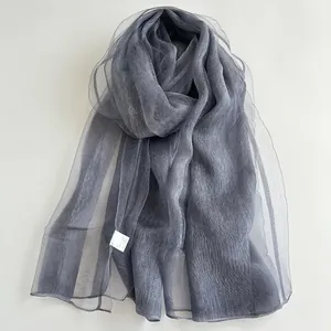 Detail view of charcoal grey pleated silk scarf with semi-transparent texture and wavy edges