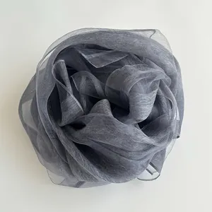 Detailed macro view of dark grey translucent mesh silk scarf folded into a rose petal shape