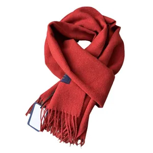 Classic red wool scarf with tassels and navy blue label for autumn and winter season