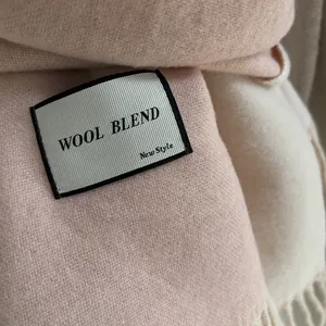 Detail shot of soft wool blend scarf featuring elegant fringe and a plush texture