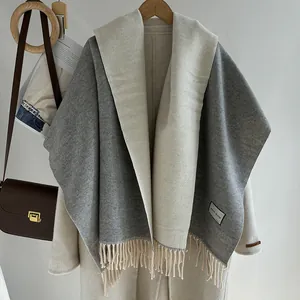 Detail of wool blend scarf with fringe hem and texture on a stylish white coat