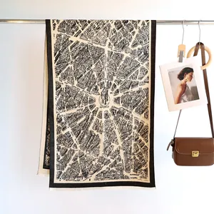 Detail of vintage Paris map jacquard pattern on soft beige cashmere-like winter scarf