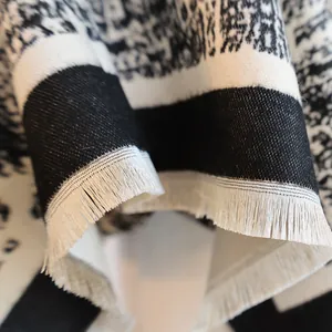 Macro shot of abstract black and white jacquard fabric with delicate white fringe detail