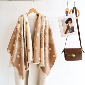Détails d'une écharpe fleurie beige avec franges sur un manteau en laine élégant