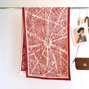 Detail view of burgundy cashmere-like scarf with vintage Paris map jacquard and fringe