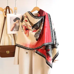 Detail of a floral cashmere-feel scarf with Hand Made label on a beige coat