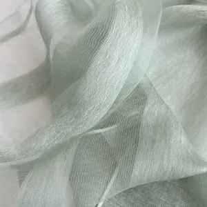 Detailed macro view of mint green sheer fabric with a pearlescent texture and fine vertical lines