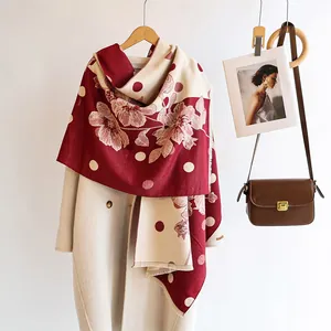 Texture détaillée d'une écharpe d'hiver épaisse avec fleurs bordeaux et pois