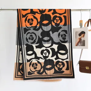 Detail of camellia patterned cashmere-like shawl with tassels and elegant patchwork design