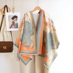 Detail of floral cashmere-like shawl with blue flower print and tassels on a knit sweater