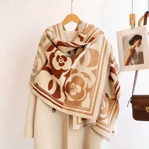 Winter cashmere feel camellia scarf with fringe detail, draped on beige coat style